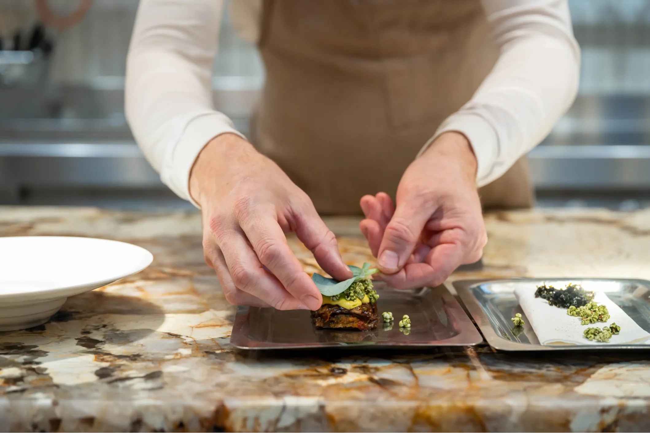 Corporate photo of a chef garnishing a dish