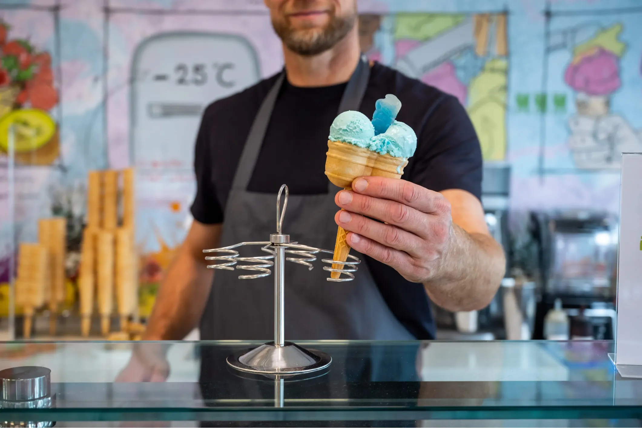 Corporate photo of a man selling scoops of ice cream behind a counter