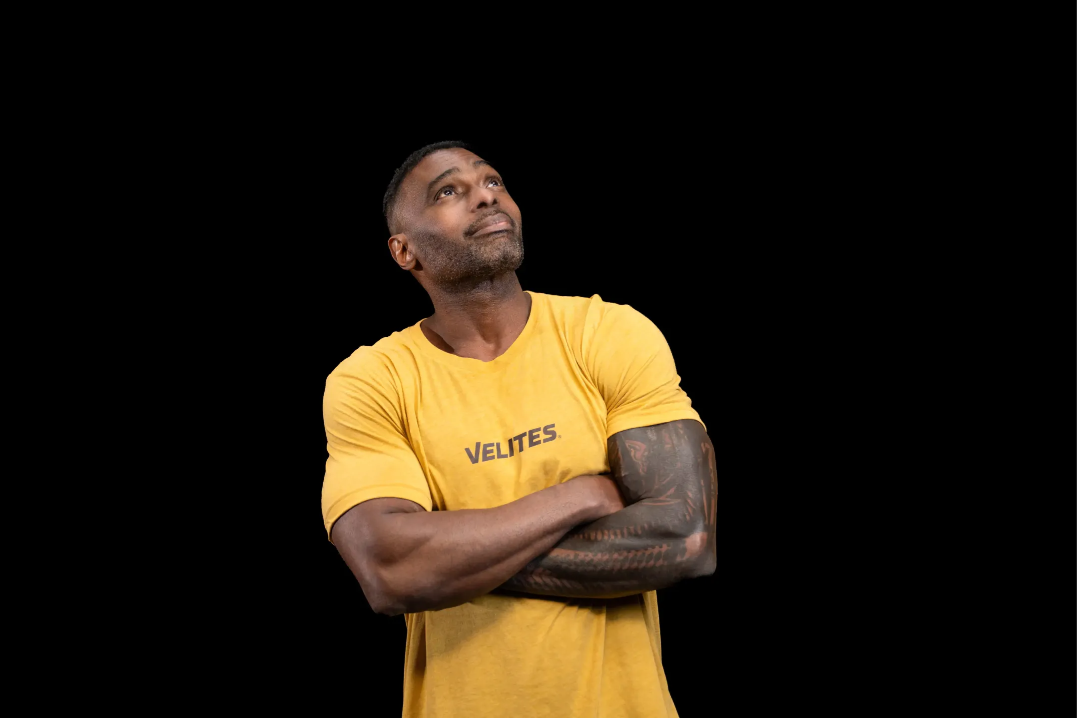 Corporate photo of a muscular man in a yellow shirt against a black background