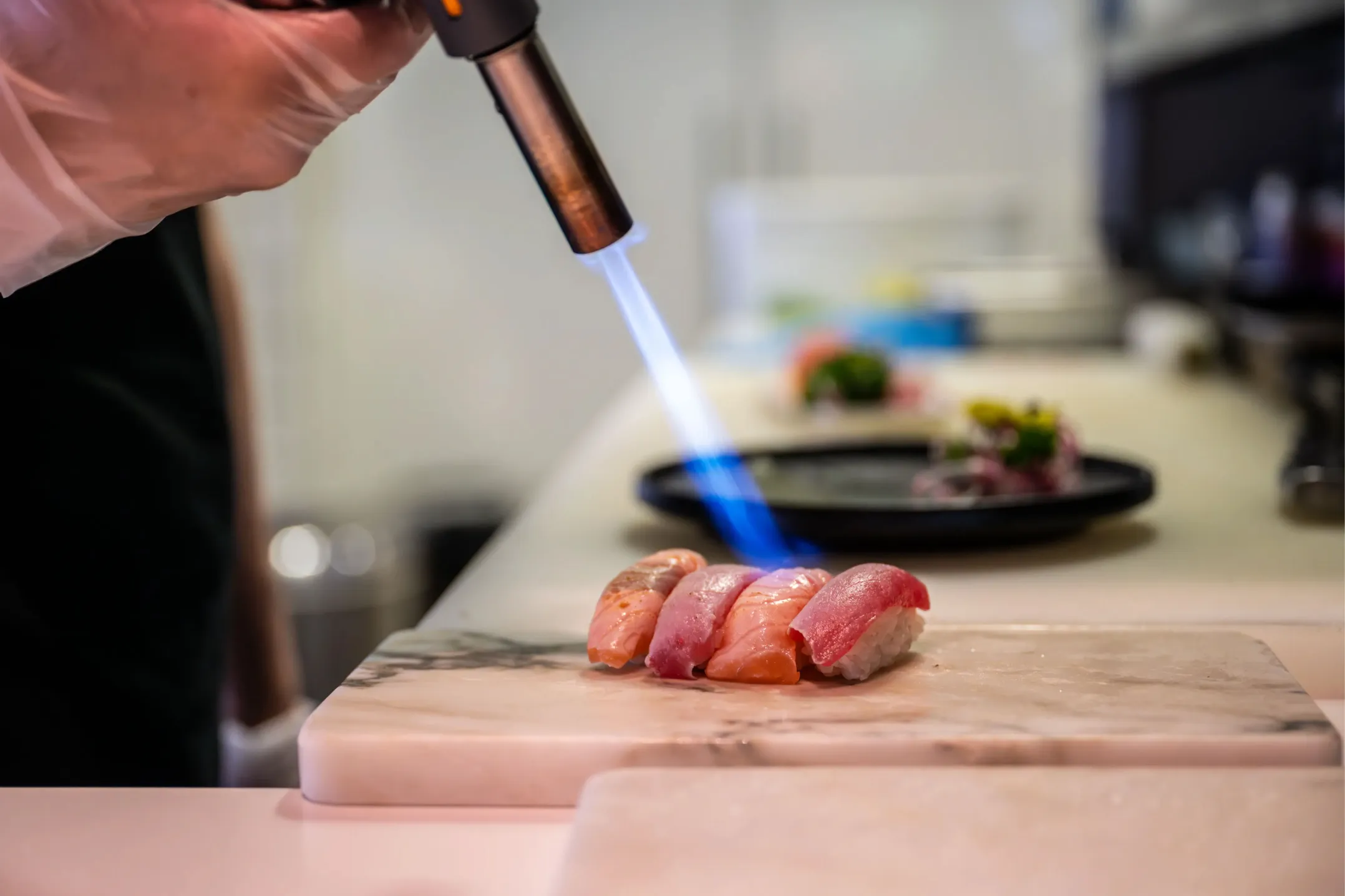 Corporate photo of sushi being flambéed with a torch