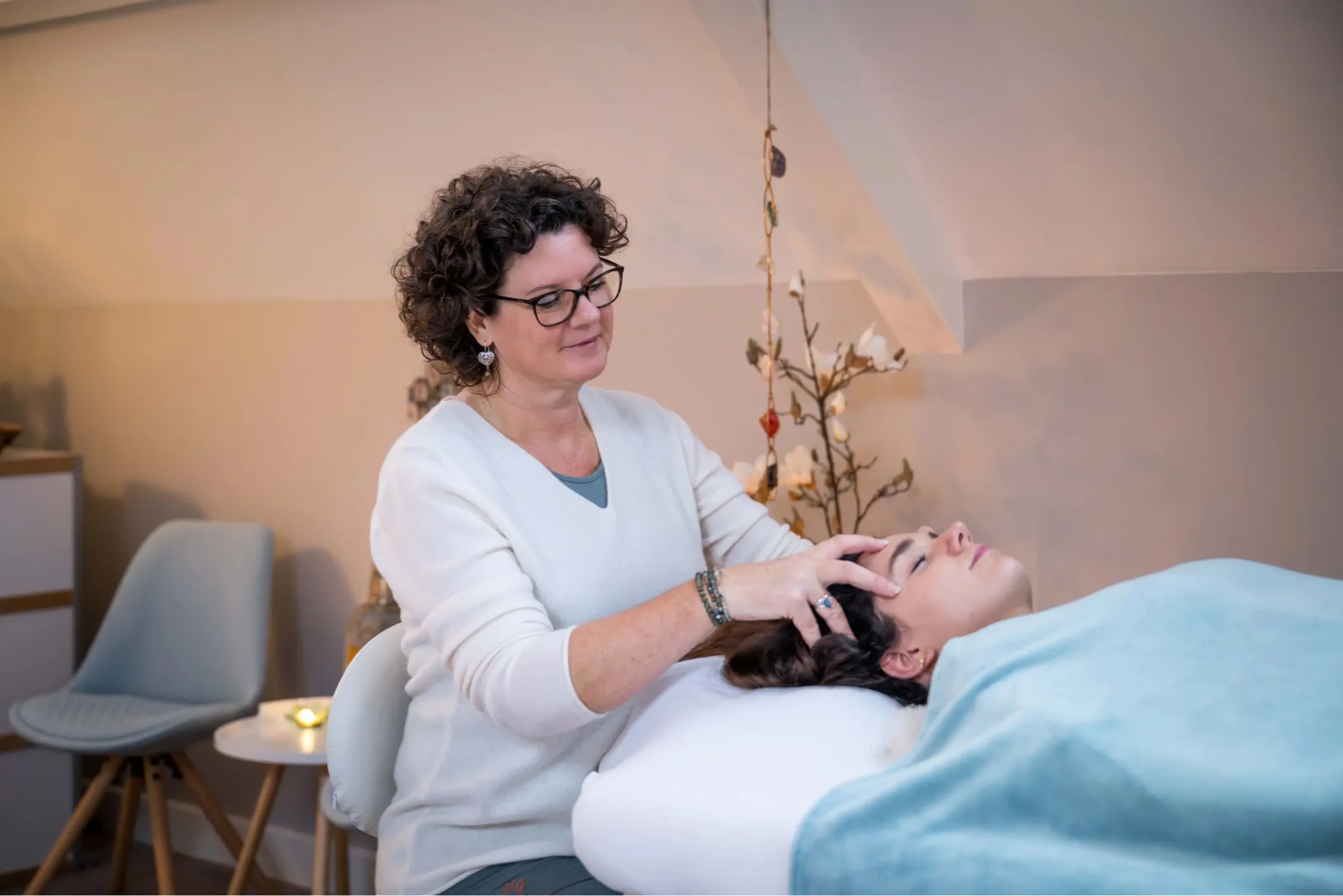 Corporate photo of a woman giving a client a head massage