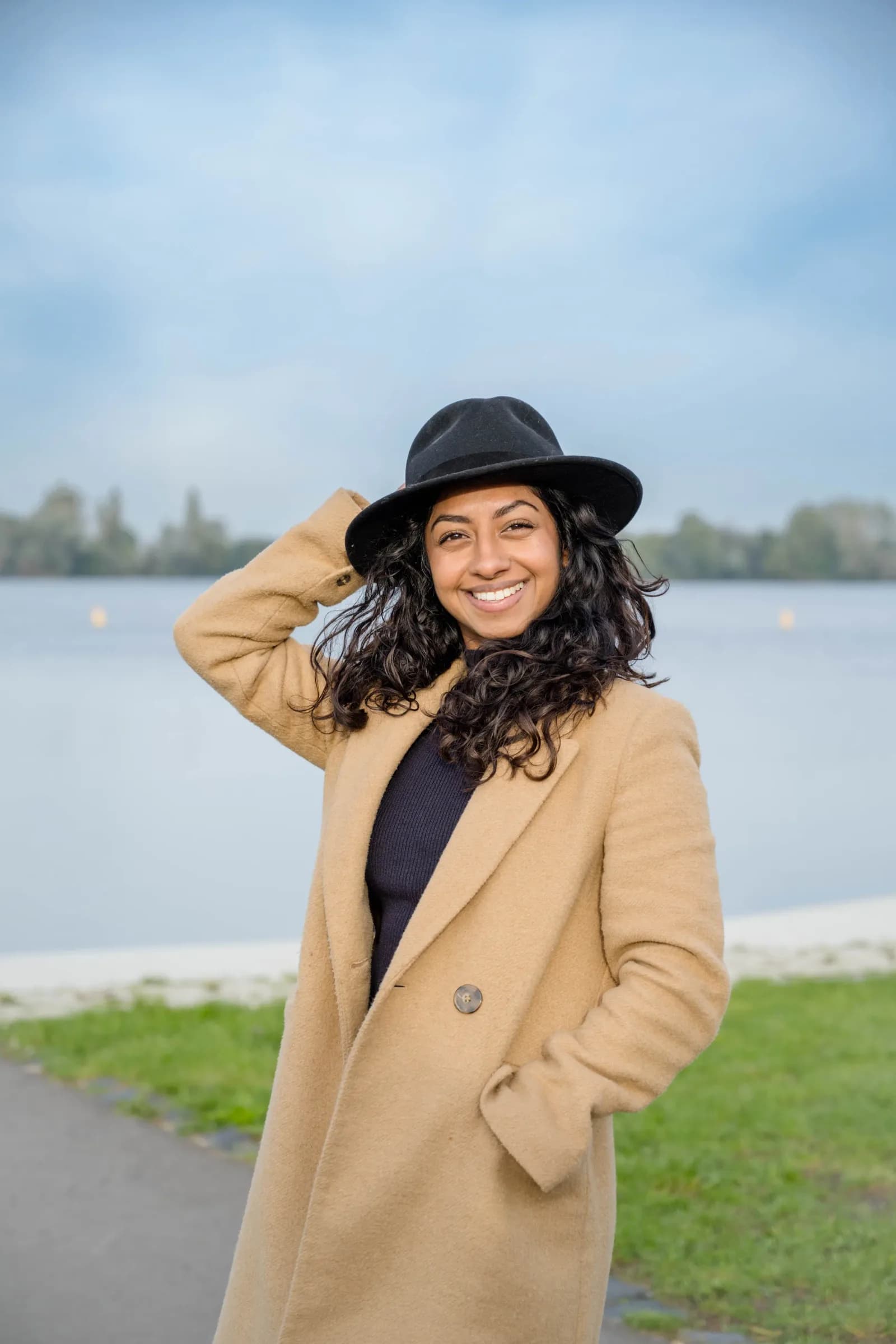 Corporate photo of a woman in a hat by the water