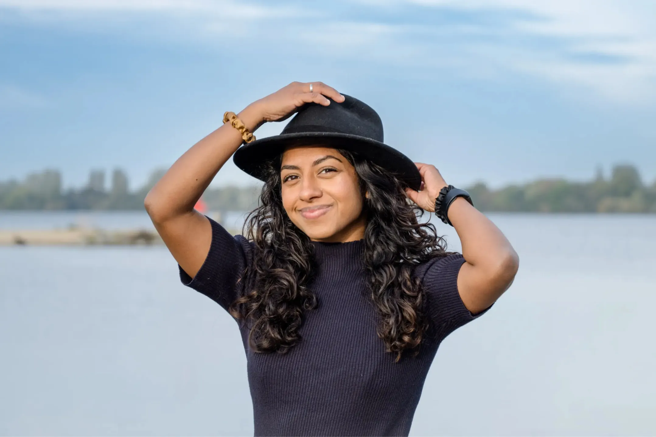 Corporate photo of a woman in a hat with water in the background