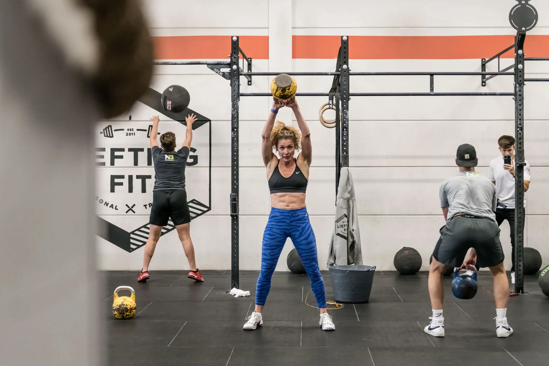 Event photo of a CrossFit woman with a kettlebell and a six-pack