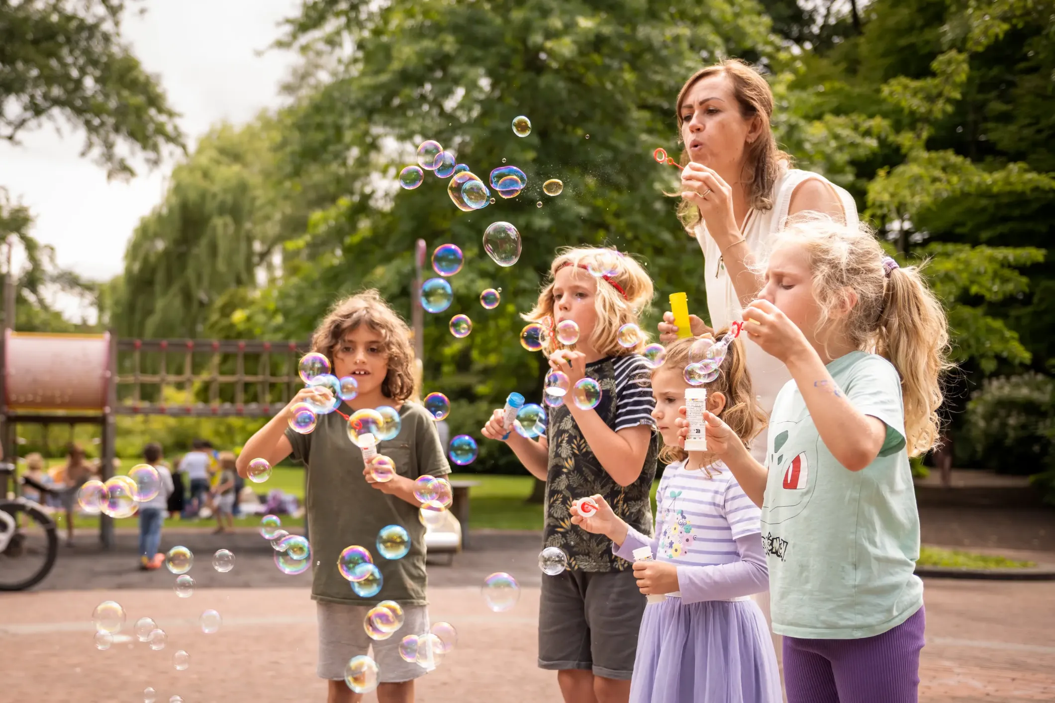 A group of children blowing bubbles in a park