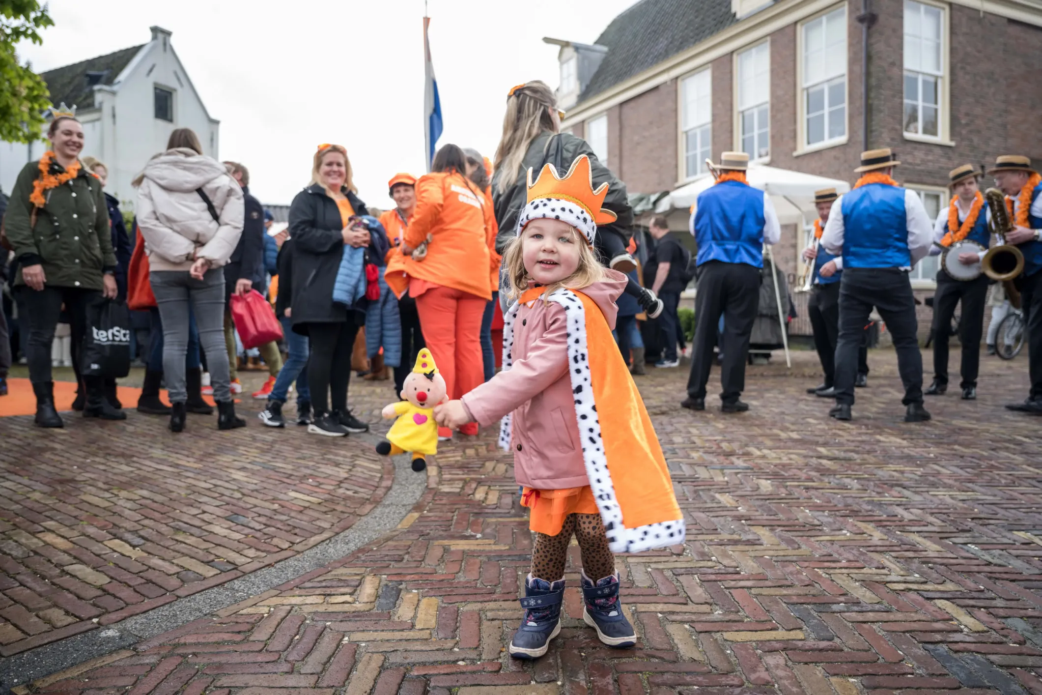 Event photo of a girl on King's Day wearing a cape and crown