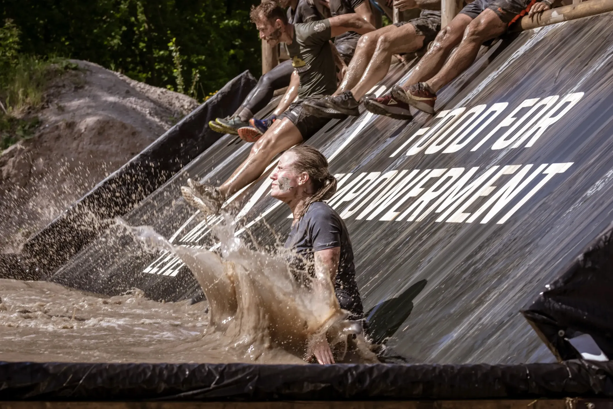 Event photo of a woman splashing through water and mud at Mud Masters