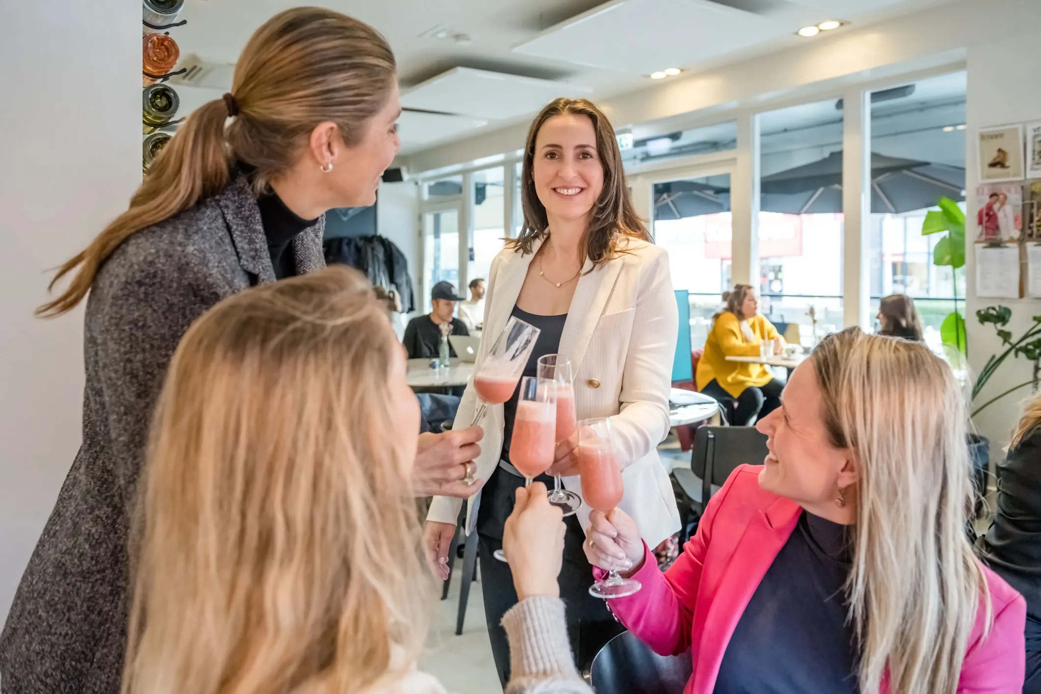 Event photo of women in suits toasting with mixed drinks