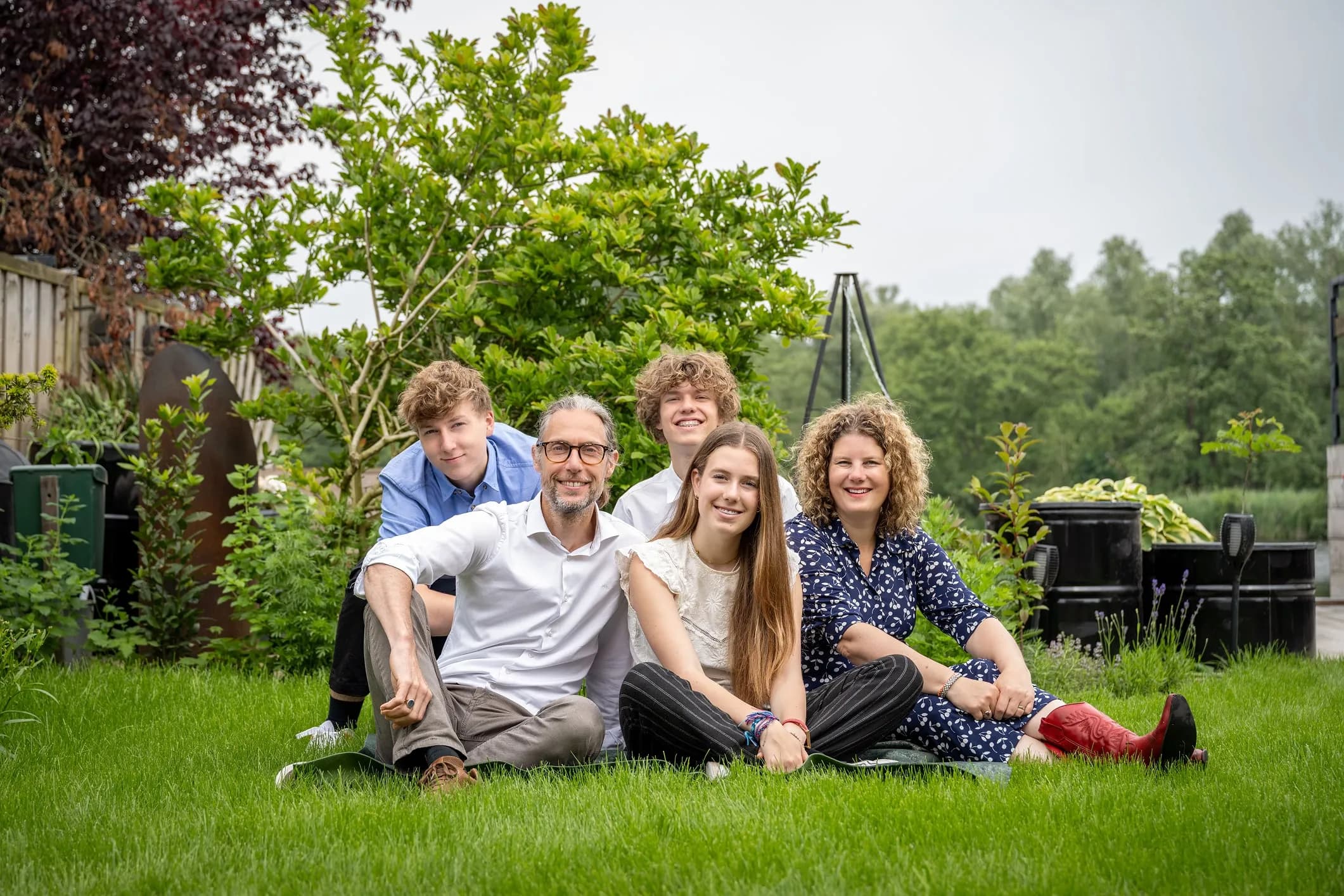 Family photo of a family of five together on the grass in their own garden