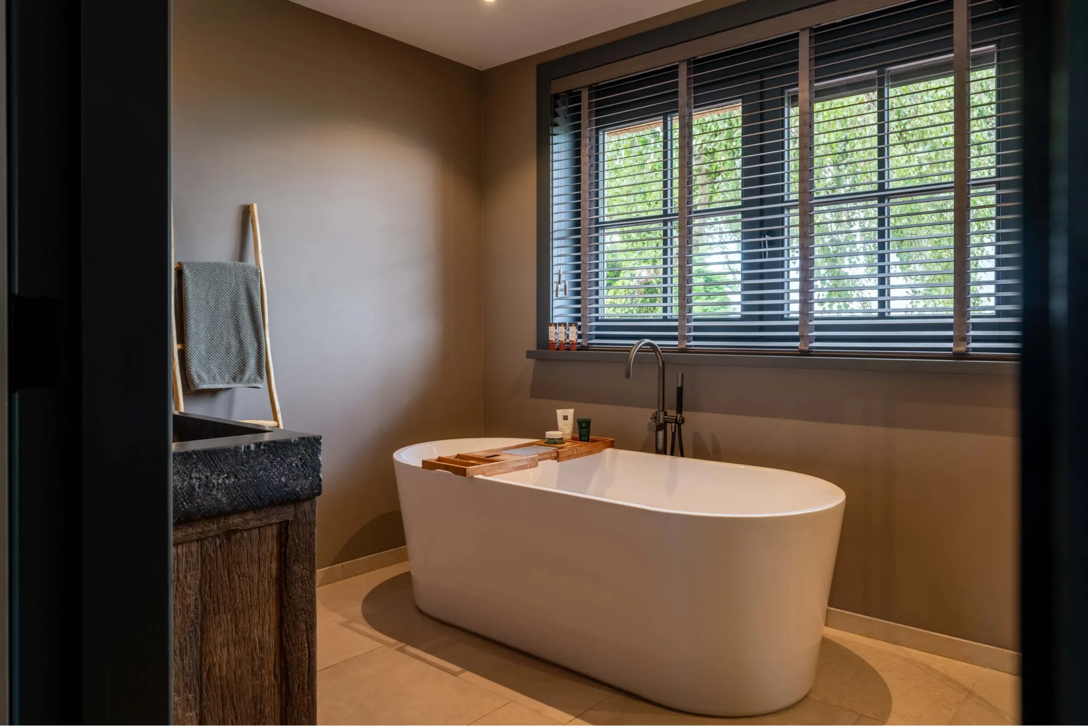 Interior photo of a bathroom with a central bath and windows