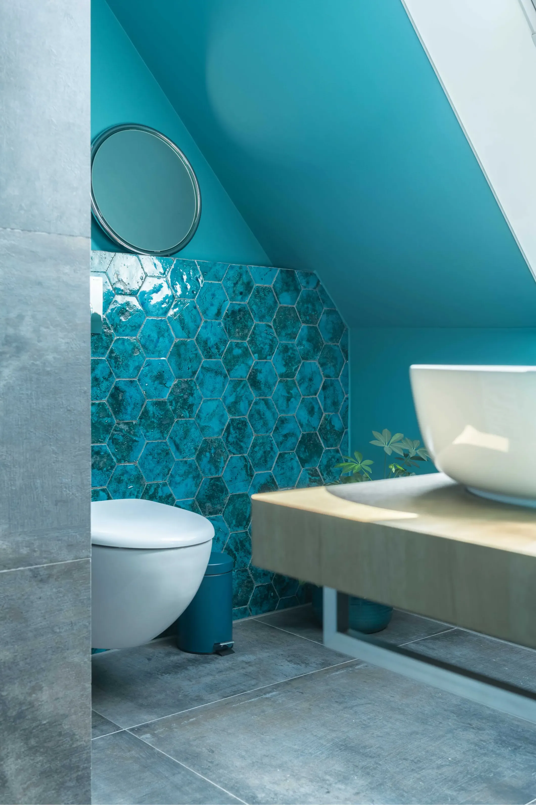 Interior photo of a bathroom with a mirror and aqua blue tiles