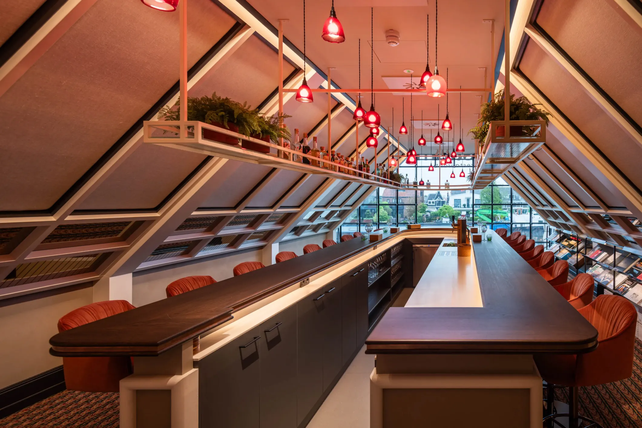 Interior photo of a bar with red chairs and lighting