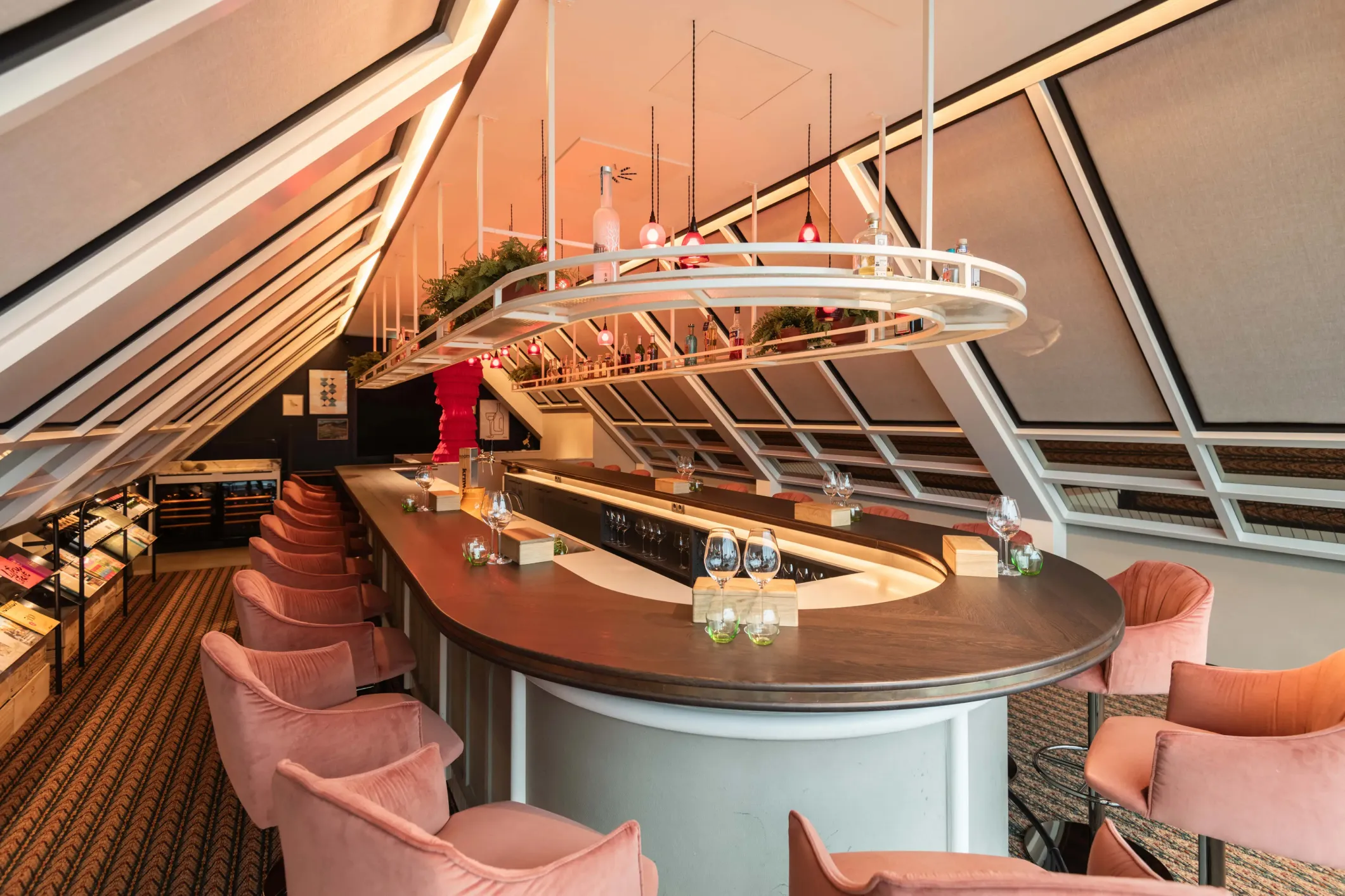 Interior photo of a bar with a round table, red chairs and round lighting