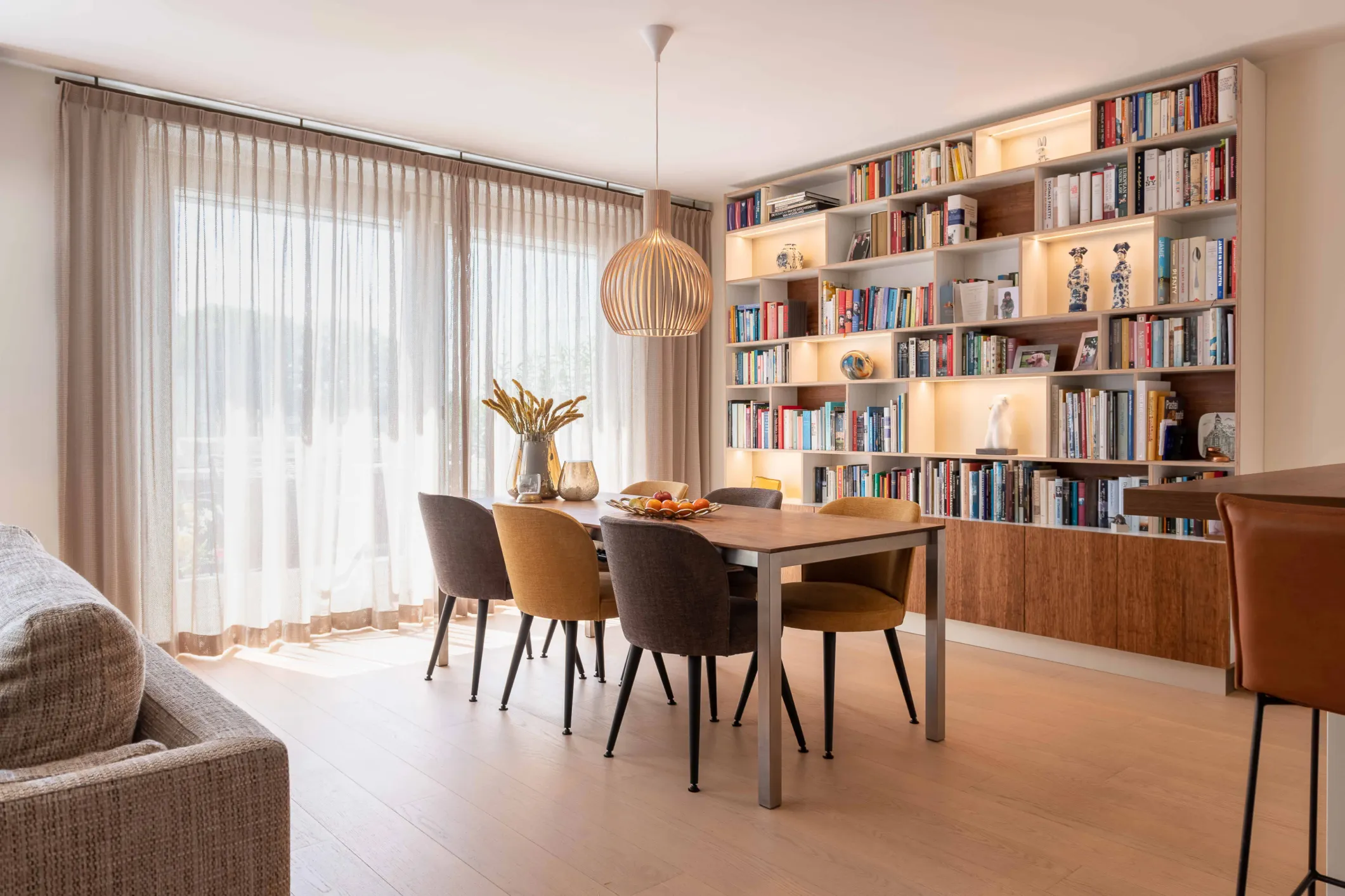 Interior photo of a large bookcase and a dining table with chairs