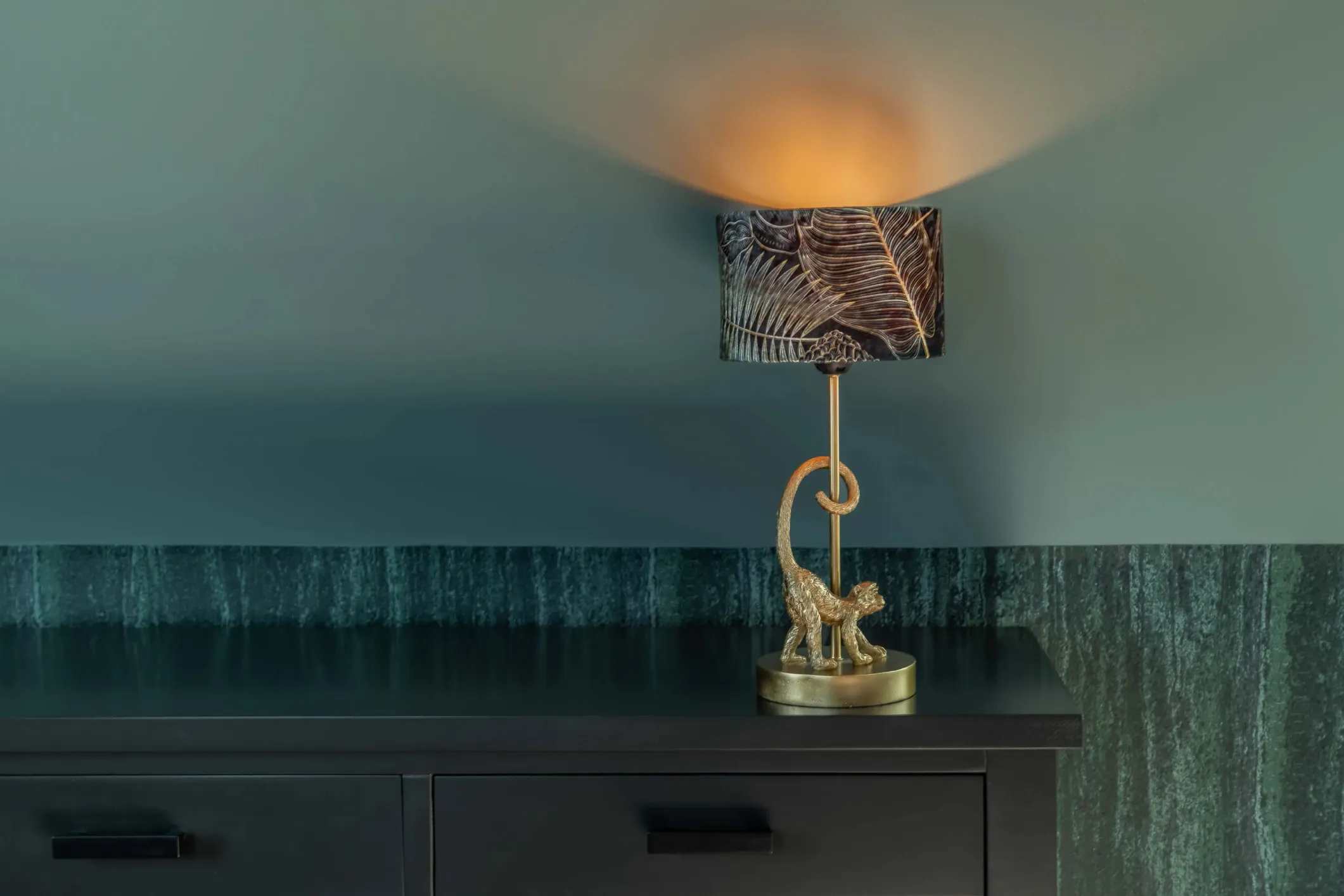 Interior photo of a black cabinet with a gold lamp