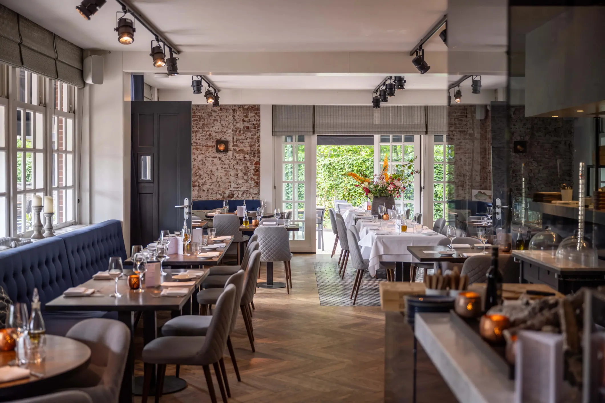 Interior photo of a restaurant with blue benches, wooden floors and studio lighting
