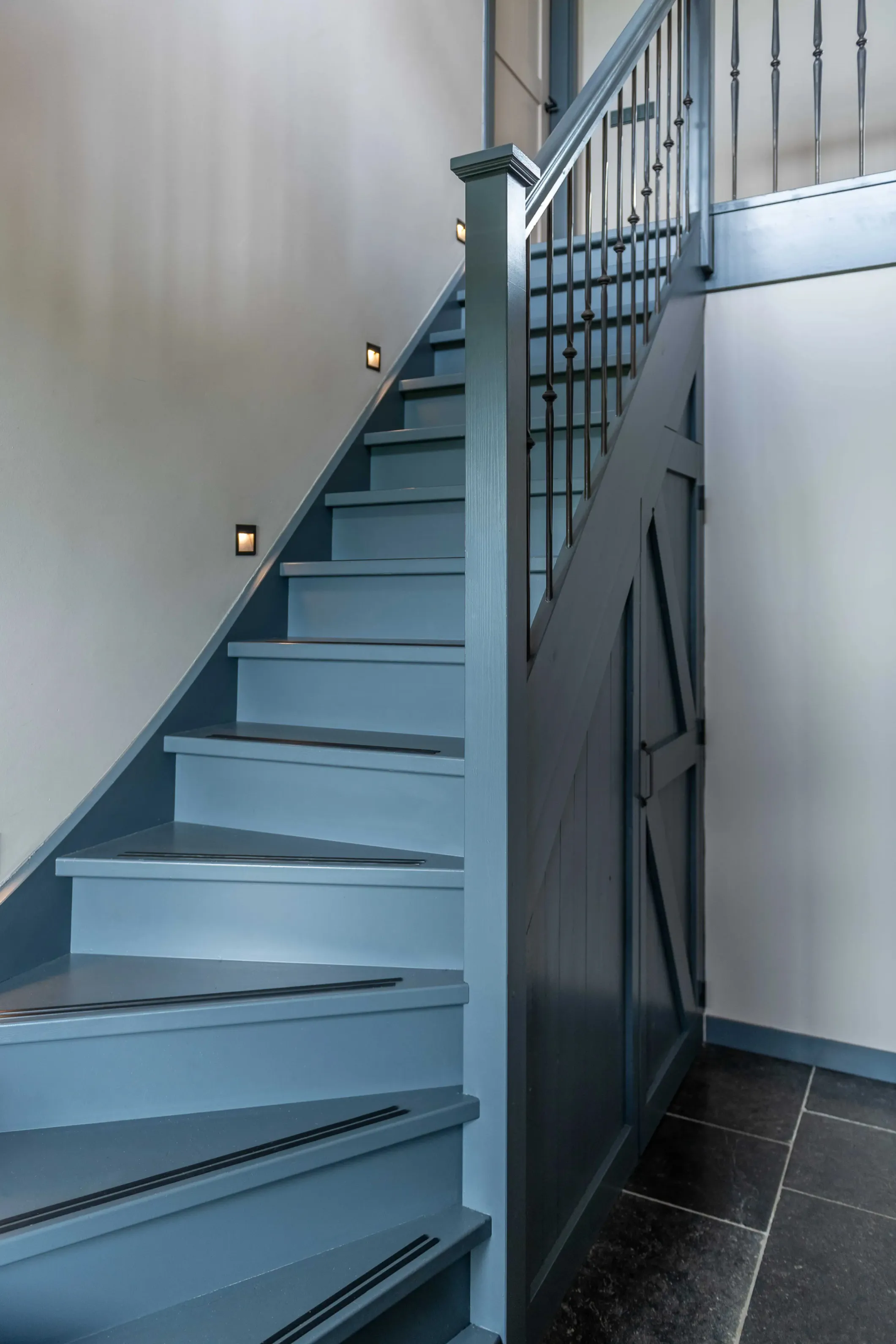 Interior photo of a lit staircase in a blue house