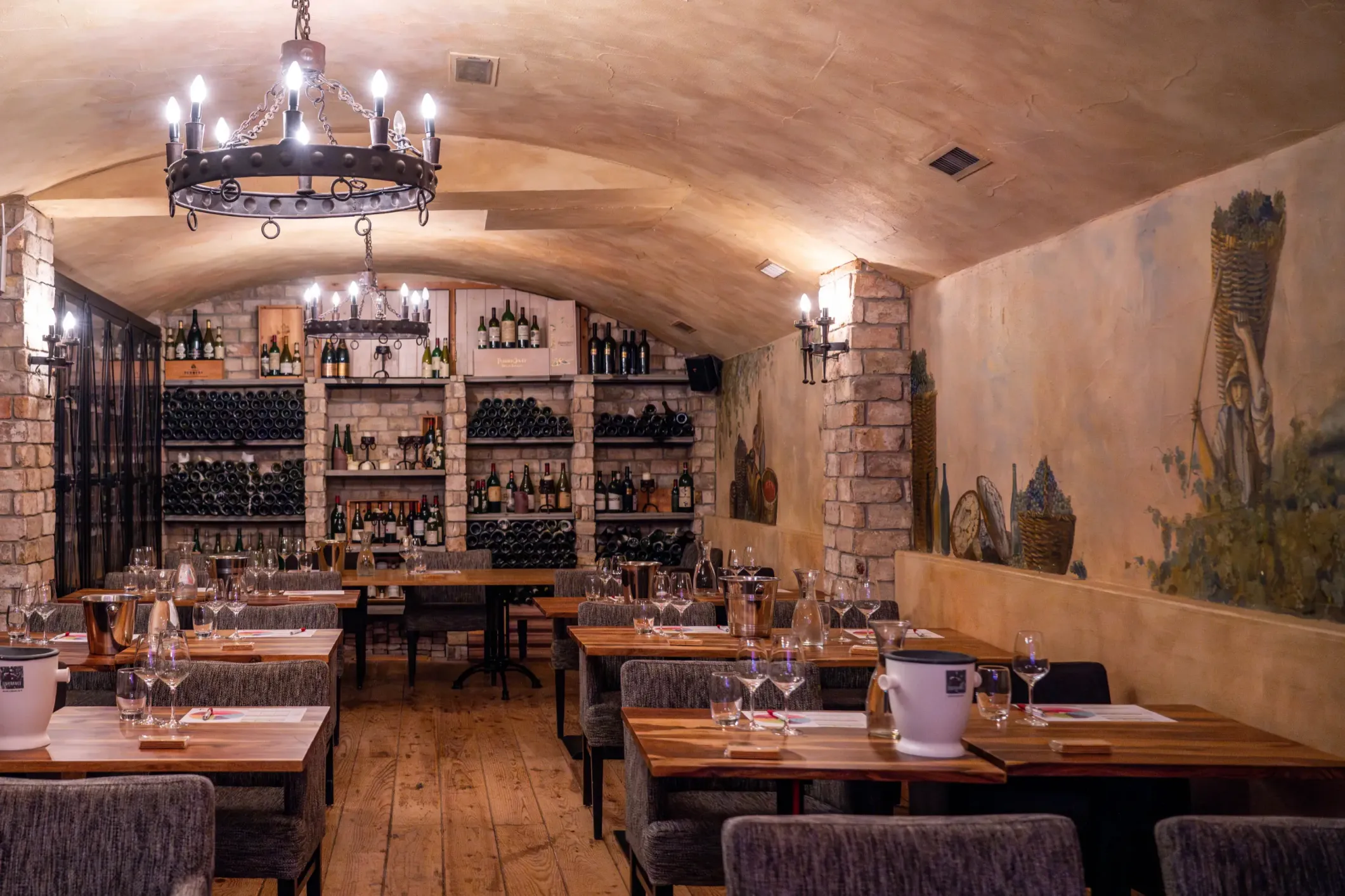 Interior photo of a cellar wine bar with tables and old chairs
