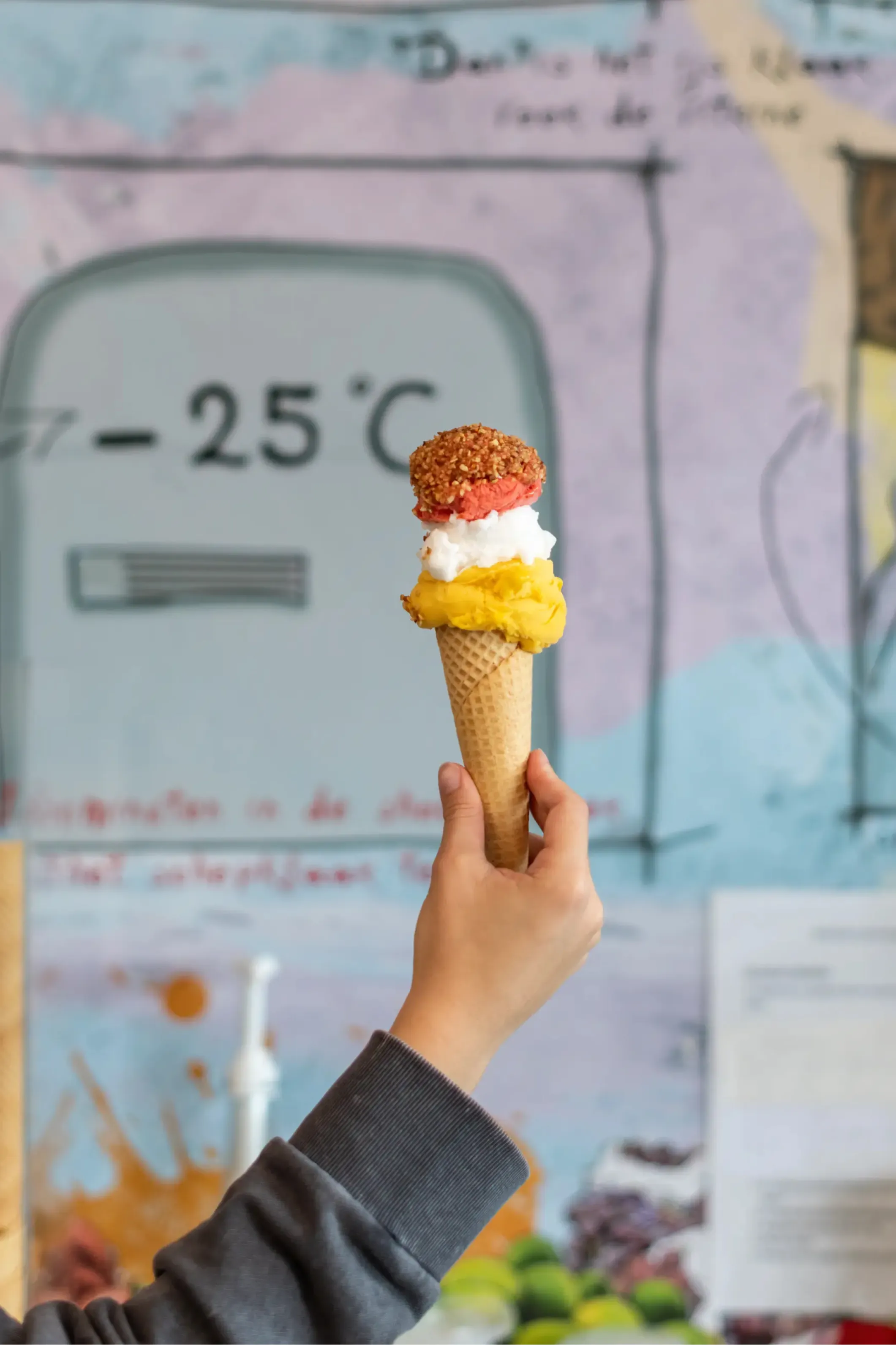 Product photo of an ice cream cone with scoops, held in a hand
