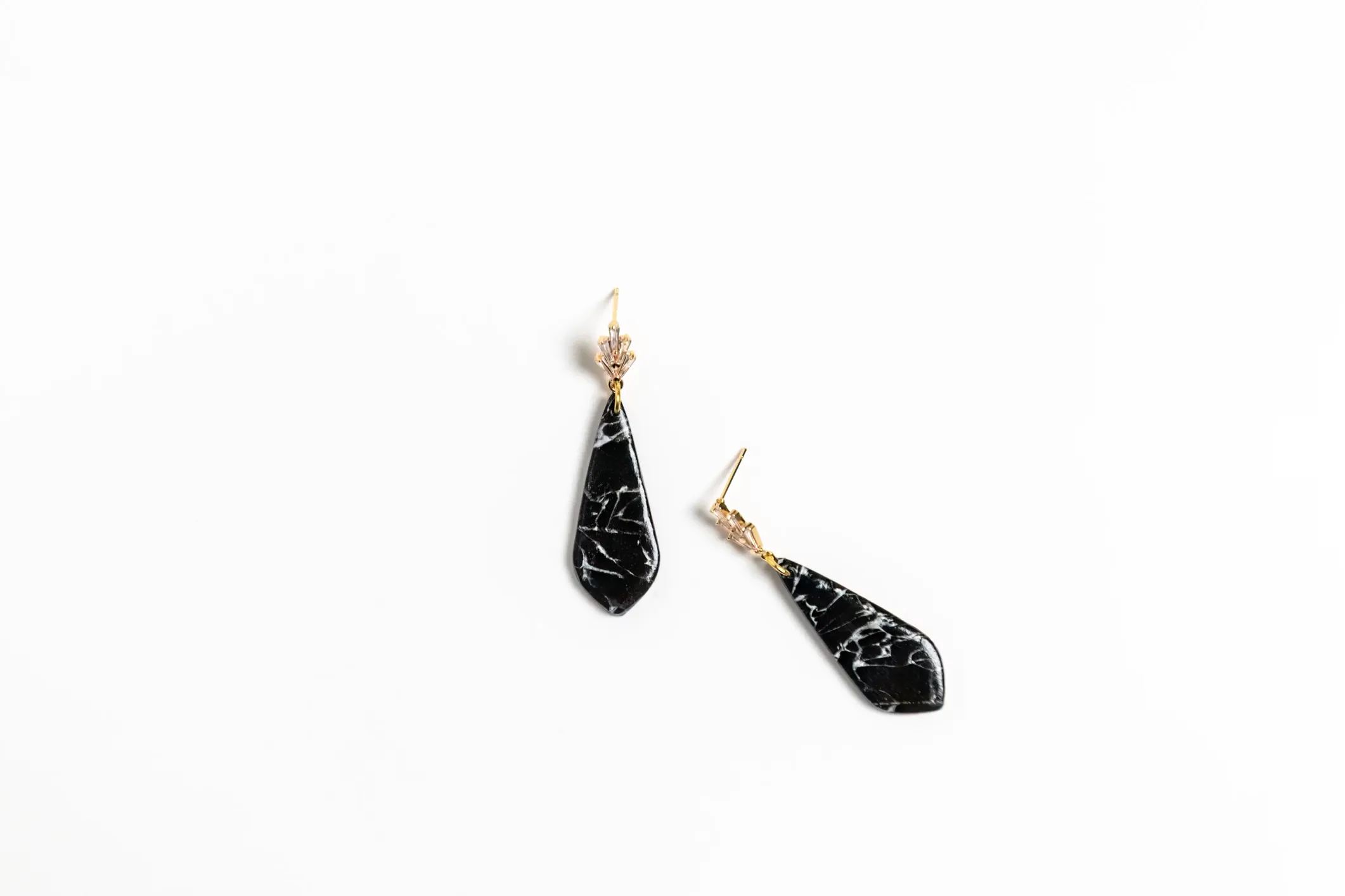 Product photo of black gemstone earrings on a white background