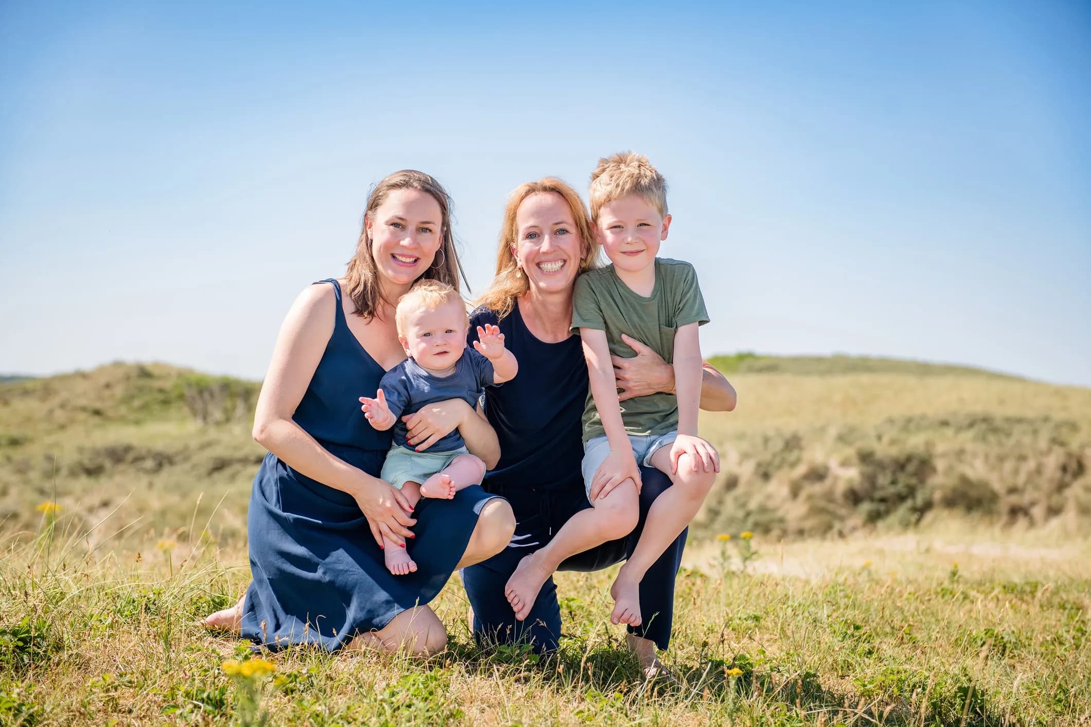 Family photo of two mothers with their children in the dunes